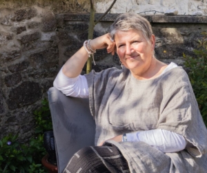 Amanda Greenwood sat on chair in garden in casual pose.