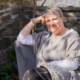 Amanda Greenwood sat on chair in garden in casual pose.